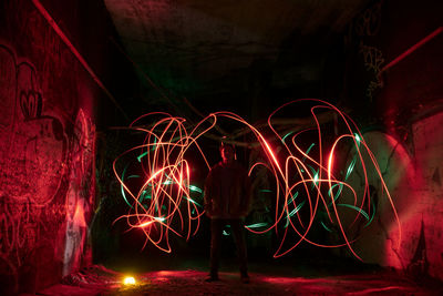Rear view of woman with light painting at night