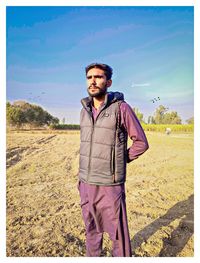 Portrait of young man standing on field