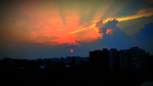 Silhouette buildings against sky during sunset