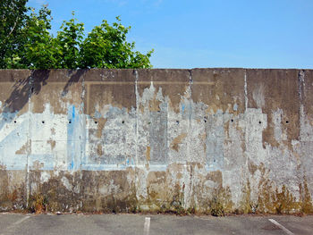 Concrete wall by building against clear blue sky