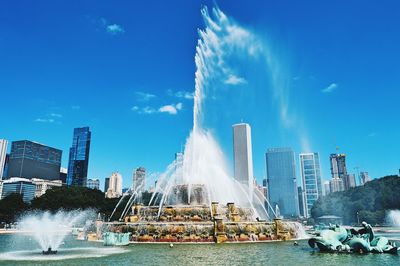 Fountain in city against sky