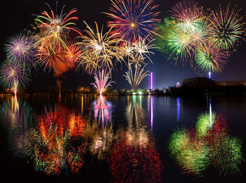 Firework display reflecting on river at night