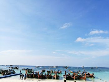 People at beach against sky