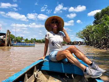 Man sitting in boat against sky