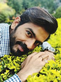 Close-up portrait of man by plants at park