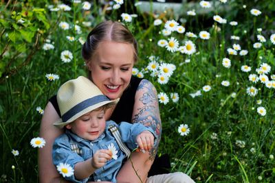 Portrait of smiling girl with flowers against plants