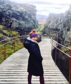 Rear view of woman on footbridge