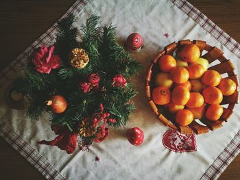 High angle view of orange fruits with christmas decorations on tablecloth