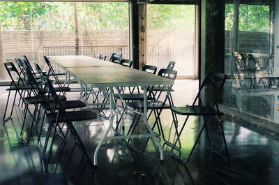 Empty chairs and tables in glass window