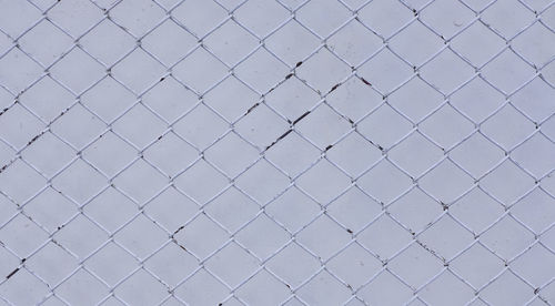 Full frame shot of metal fence against wall