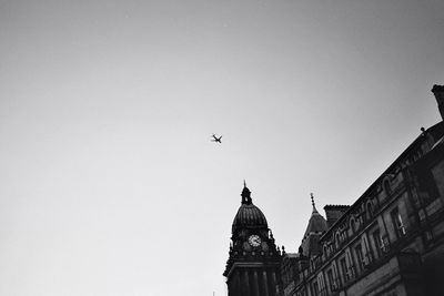 Low angle view of birds flying against clear sky