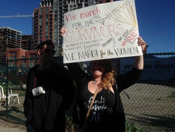 Woman with text standing against sign