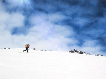 Man skiing on snowcapped mountain against sky