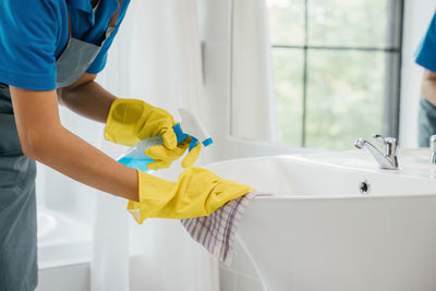 Midsection of man washing hands in bathroom