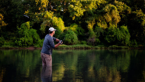 Rear view of man fishing in lake