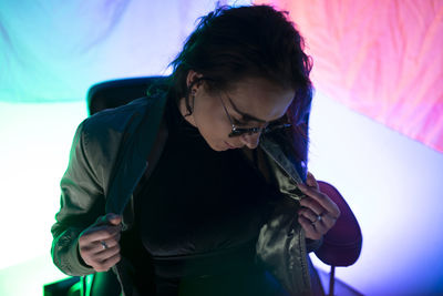 Side view of young woman looking away while standing in car