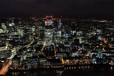 Illuminated cityscape against sky at night