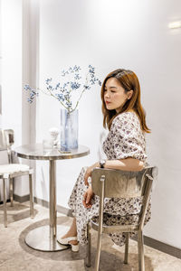 Woman smiling while sitting on table