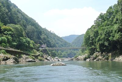 Scenic view of river and mountains against sky