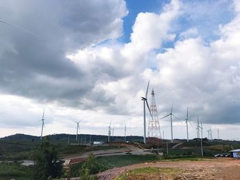 Windmills on farm against sky