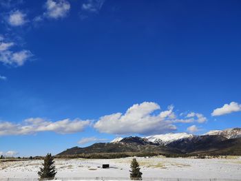 Scenic view of snowcapped mountains against blue sky