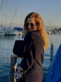 Young woman in sunglasses against sea