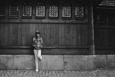 Full length of woman standing against building