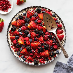 An above view of a delicious mixed berry cheesecake tart, ready for serving.