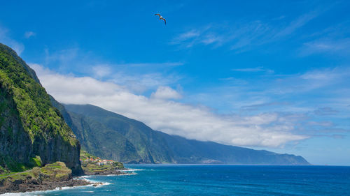 Scenic view of sea and mountains against sky