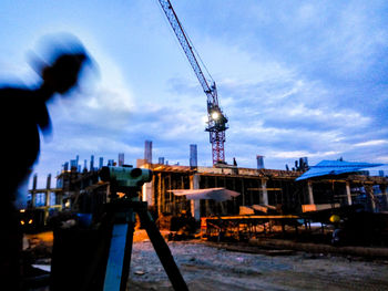 Man working in factory against sky