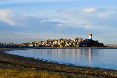 Scenic view of sea by buildings against sky