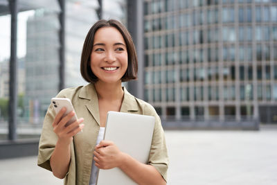 Portrait of young woman using mobile phone