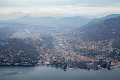 Aerial view of townscape and mountains against sky