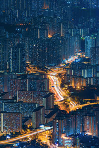 High angle view of illuminated street amidst buildings at night