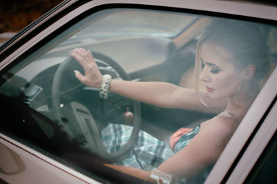 Reflection of woman in mirror car