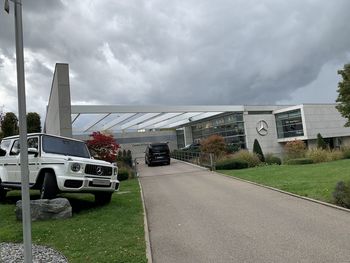 Cars on road by buildings against sky