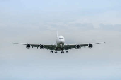 Low angle view of airplane flying against sky