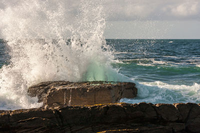 Waves splashing on rock against sea