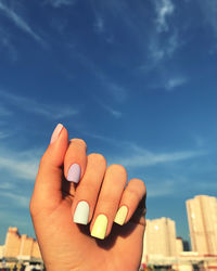 Close-up of human hand against sky