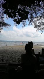 Rear view of man sitting on beach