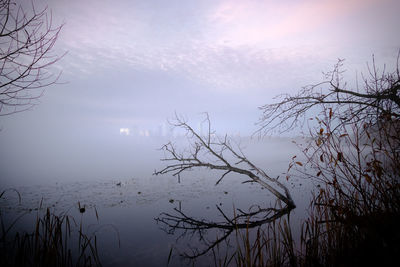 Scenic view of lake against sky during foggy weather