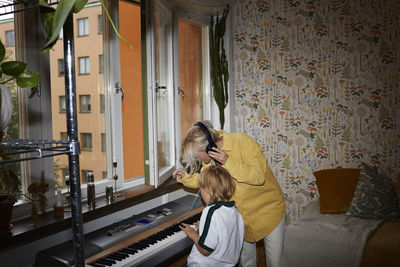 Mother listening son playing keyboard