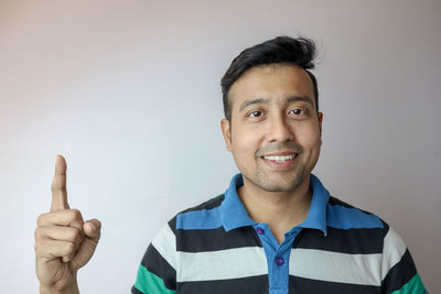 Portrait of smiling young man against white background