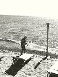 Man standing on beach against clear sky