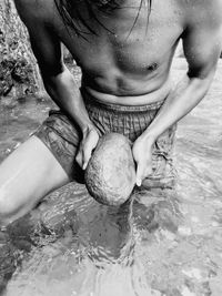 Midsection of boy holding water