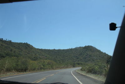 Empty road against clear blue sky