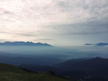 Scenic view of mountains against cloudy sky