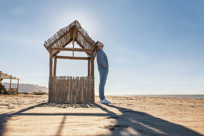 Woman standing on beach against sky