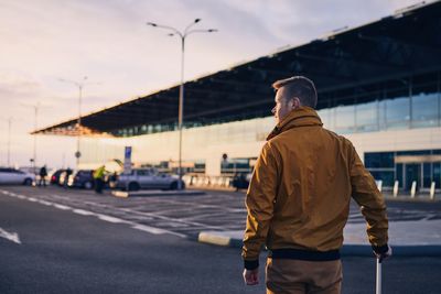 Rear view of man walking on road