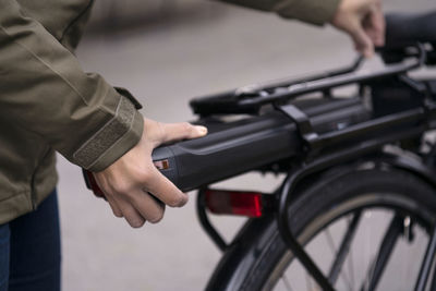 Woman fitting battery on electric bike